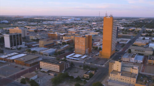 Cityscape with buildings, streets and light pink sky