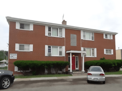 6 unit apartment building with red front door and cars parked on street