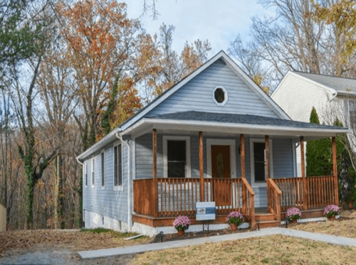 Renovated home with new roof, porch and landscaping with pink flowers