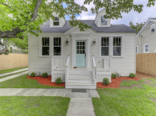 Small house with porch, light blue door and sidewalk connected