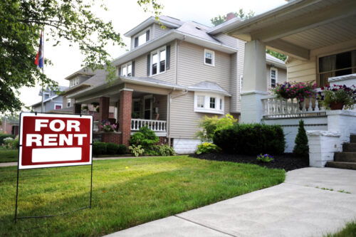 Home for Rent sign in front of large home