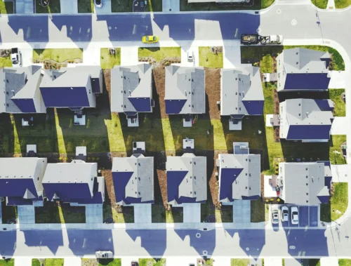 Aerial view of a row of houses and streets with cars