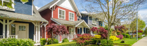 Neighborhood of brightly colored homes with sidewalk running in front of them