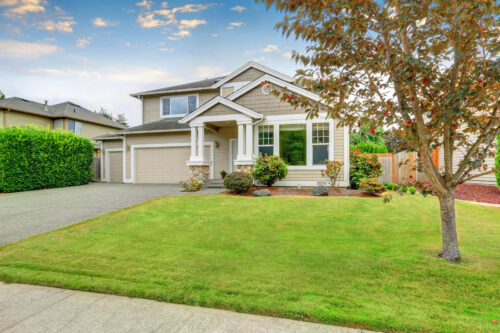 Neat beige home with two garage spaces and well kept front garden. Northwest, USA