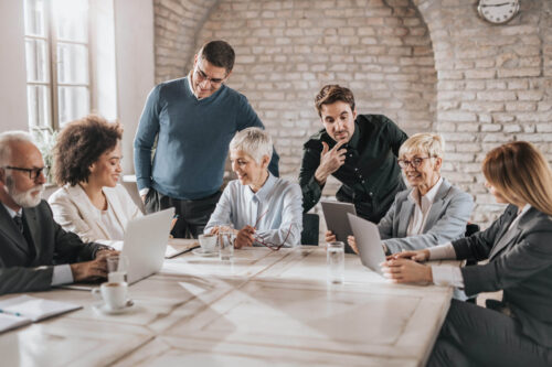 Large group of happy multi-tasking business people working on a meeting in the office.